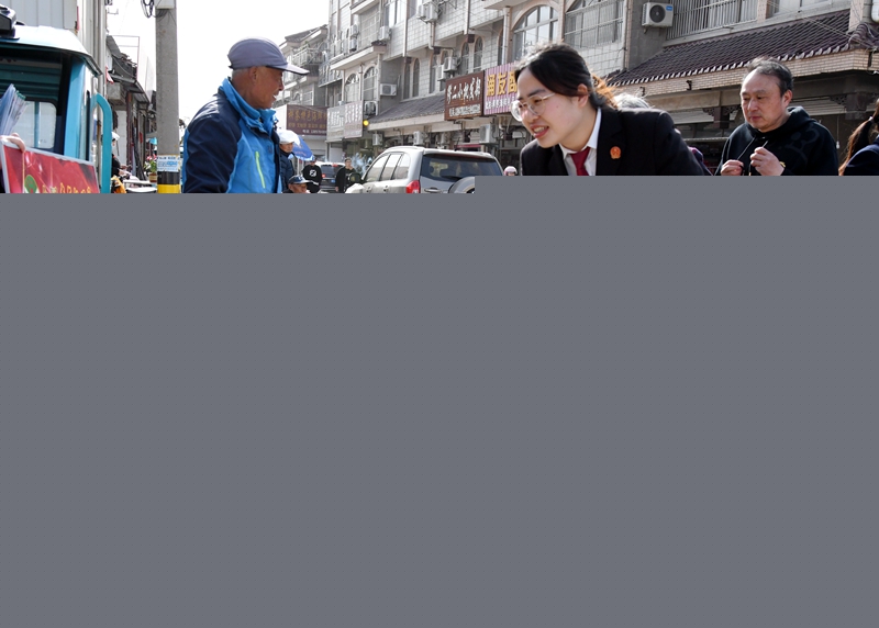①干警在“法律早市”向菜農發放普法宣傳折頁.jpg