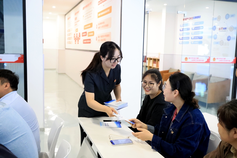 王雨璠攝 干警發放《民間借貸糾紛相關法律法規》《民營企業常見法律風險分析及典型案例》等法律宣傳手冊.JPG